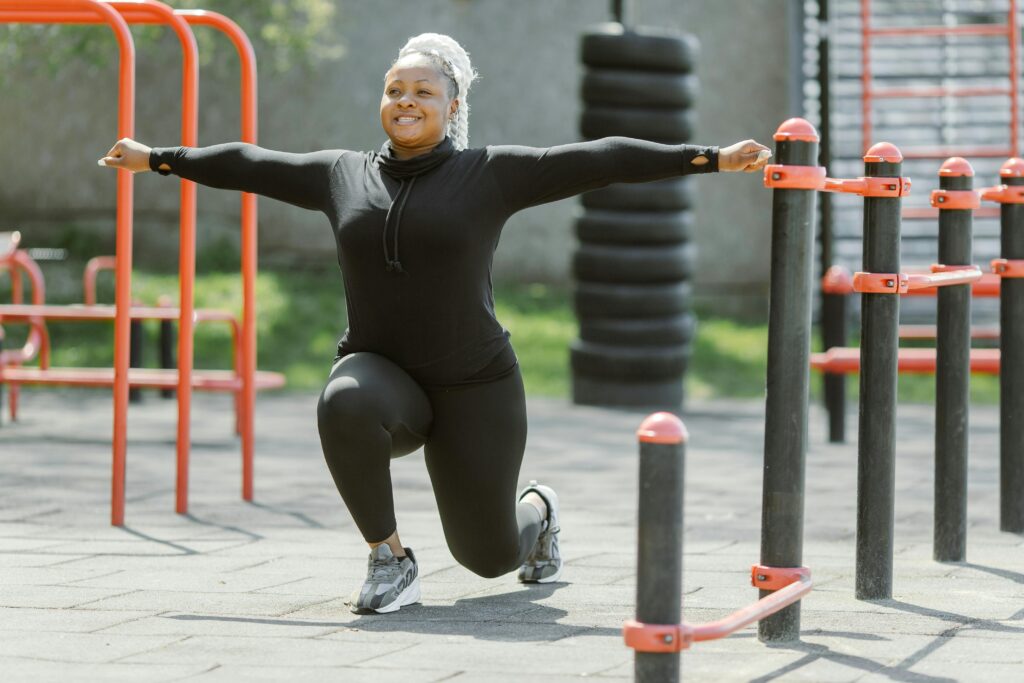 African American woman exercising in a park, promoting a healthy lifestyle.
